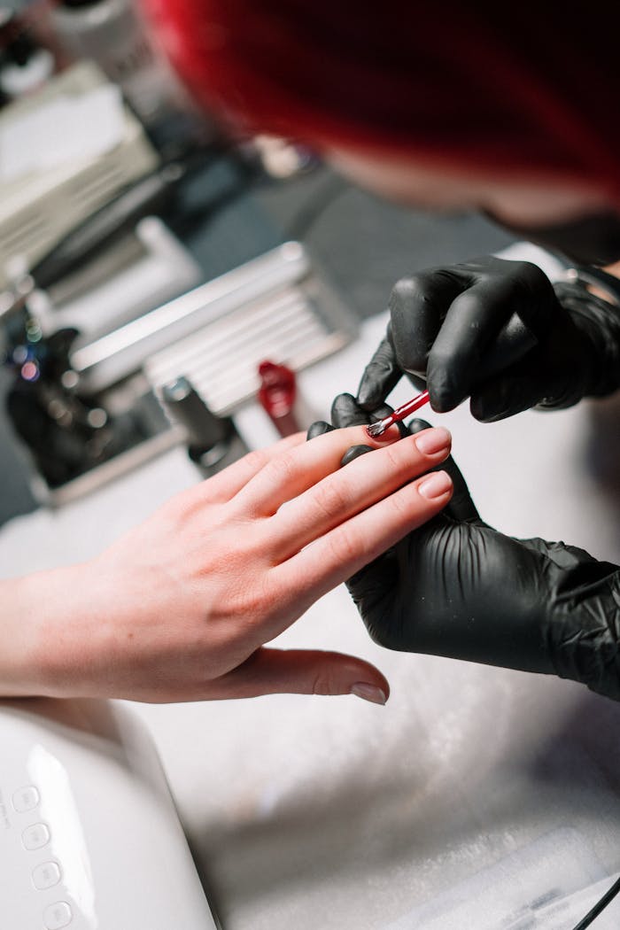 Nail artist applying gel polish in a stylish salon setting.